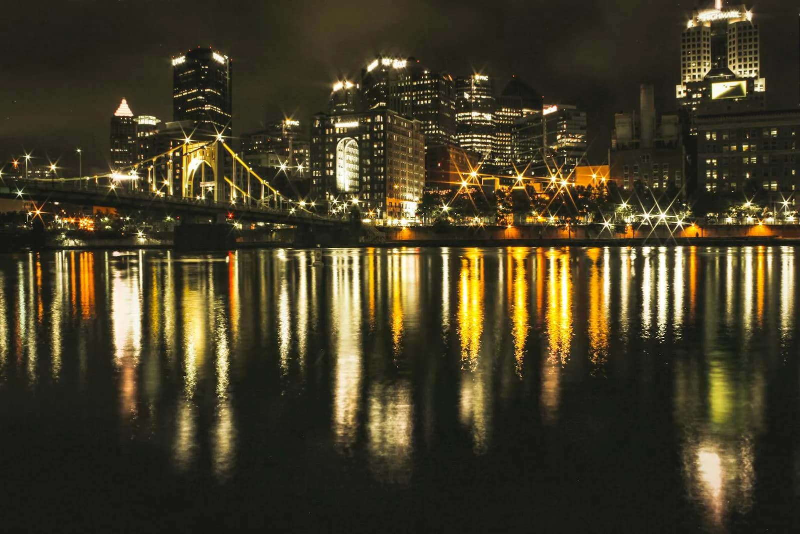 Roberto Clemente Bridge lit up at night with Pittsburgh skyline